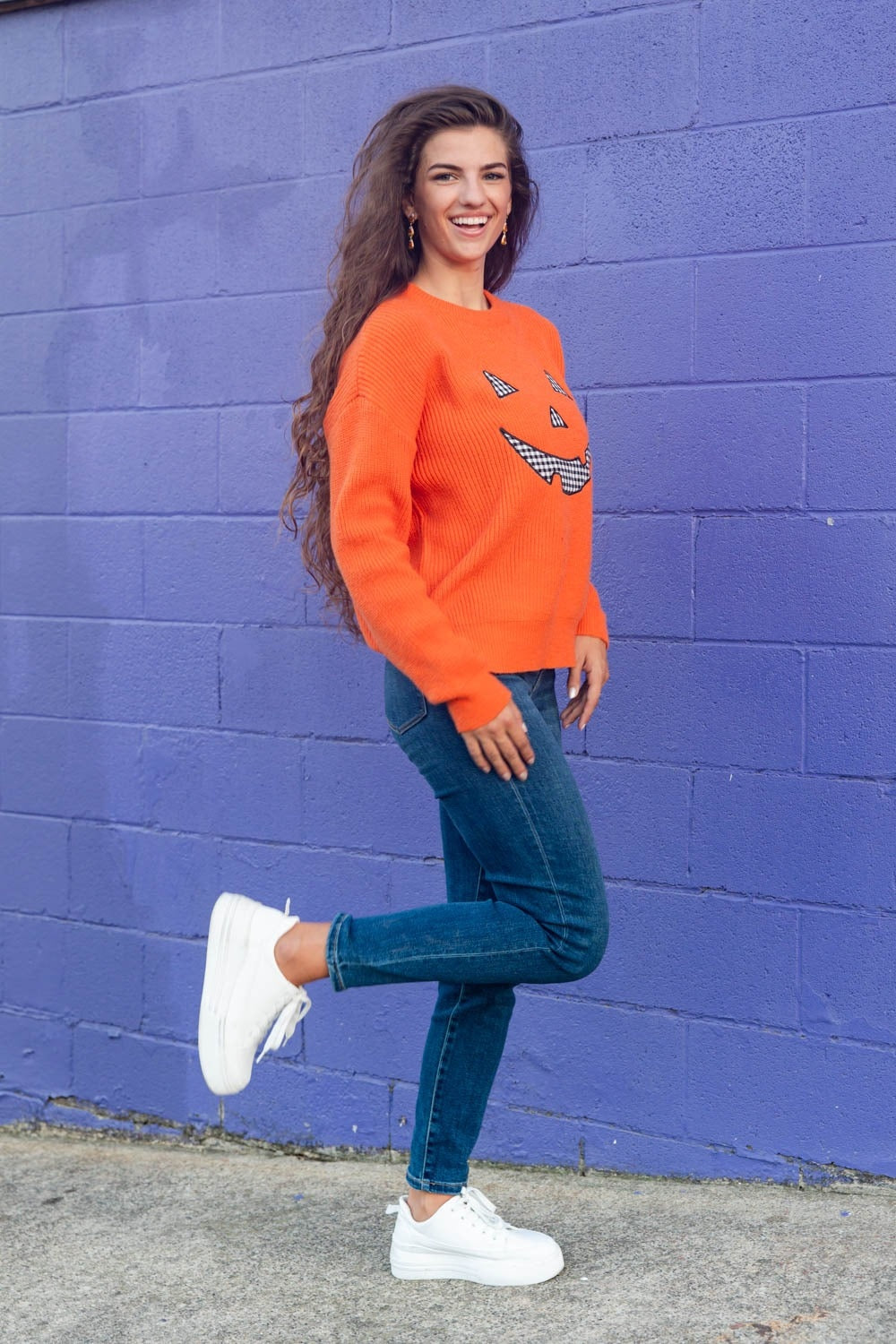 Oranje pompoentrui met jeans en witte sneakers