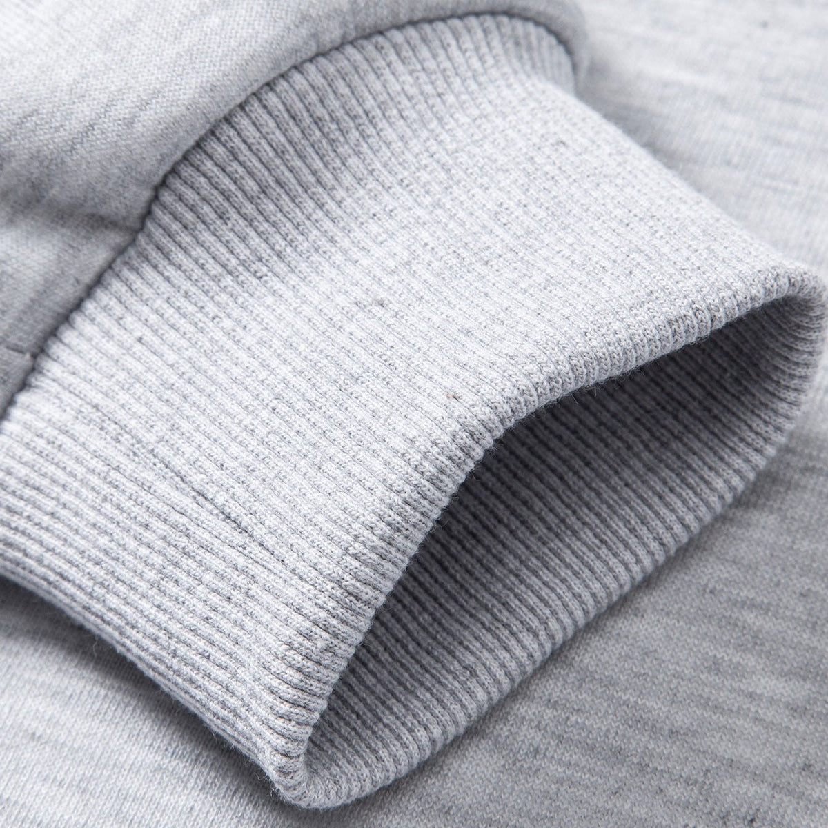 Close-up van grijze geribbelde boord aan mouw, effen patroon | Boutique Moda
