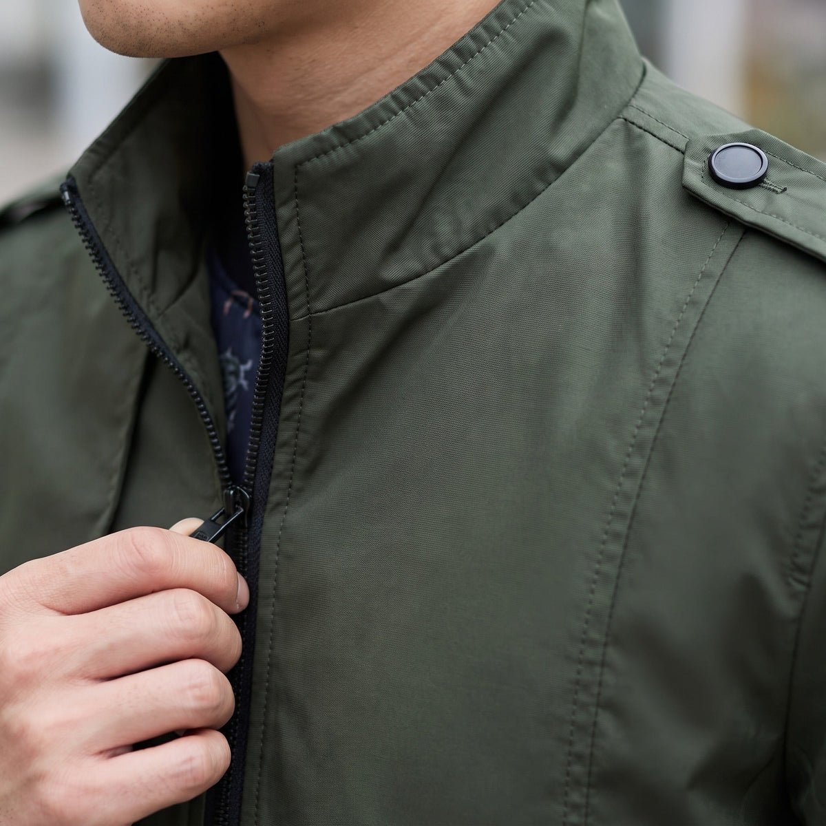 Groene jas met opstaande kraag en schoudertab, gedragen door een man | Boutique Moda