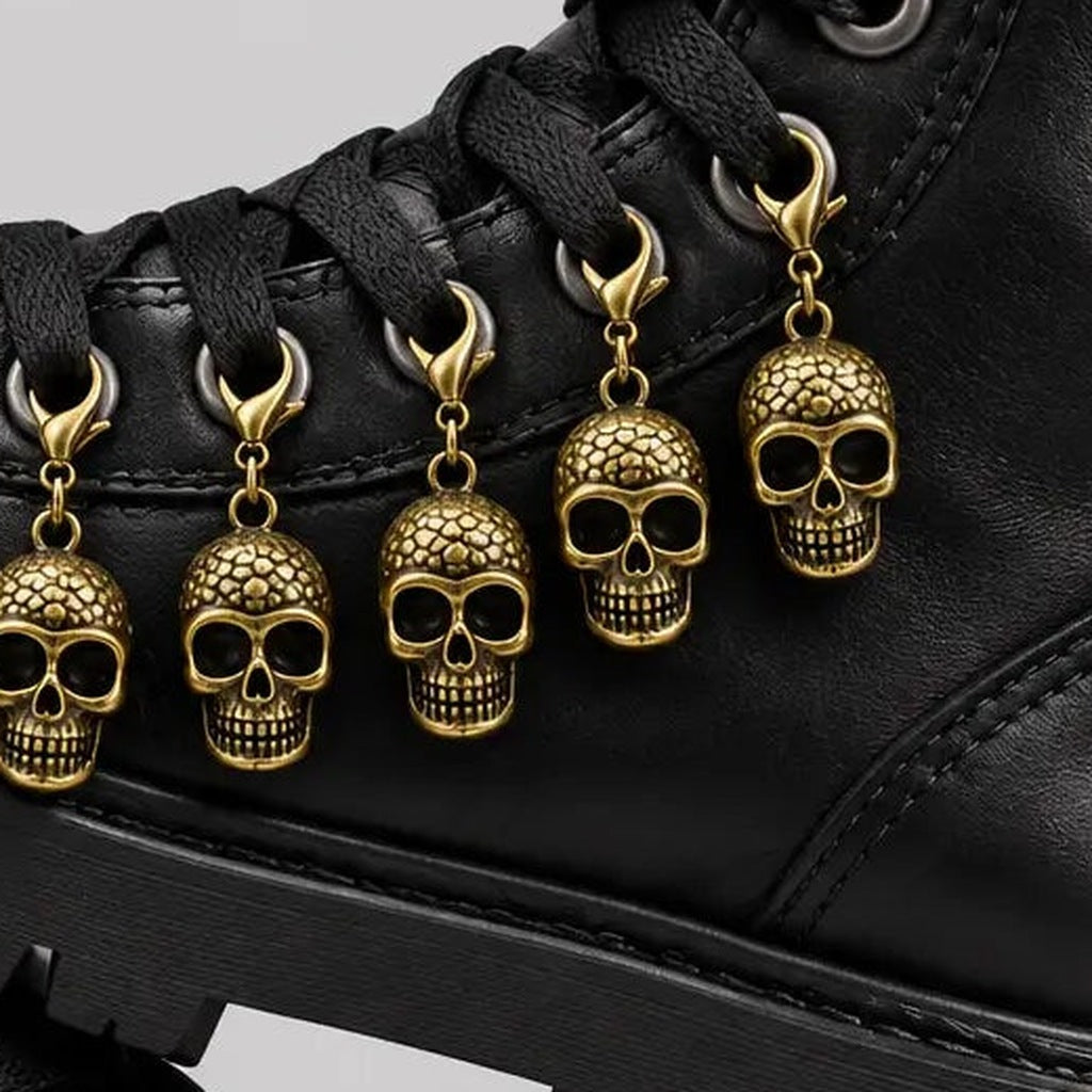 Gouden doodskop schoenbedels met karabijnsluiting bevestigd aan zwarte veterschoen | Boutique Moda