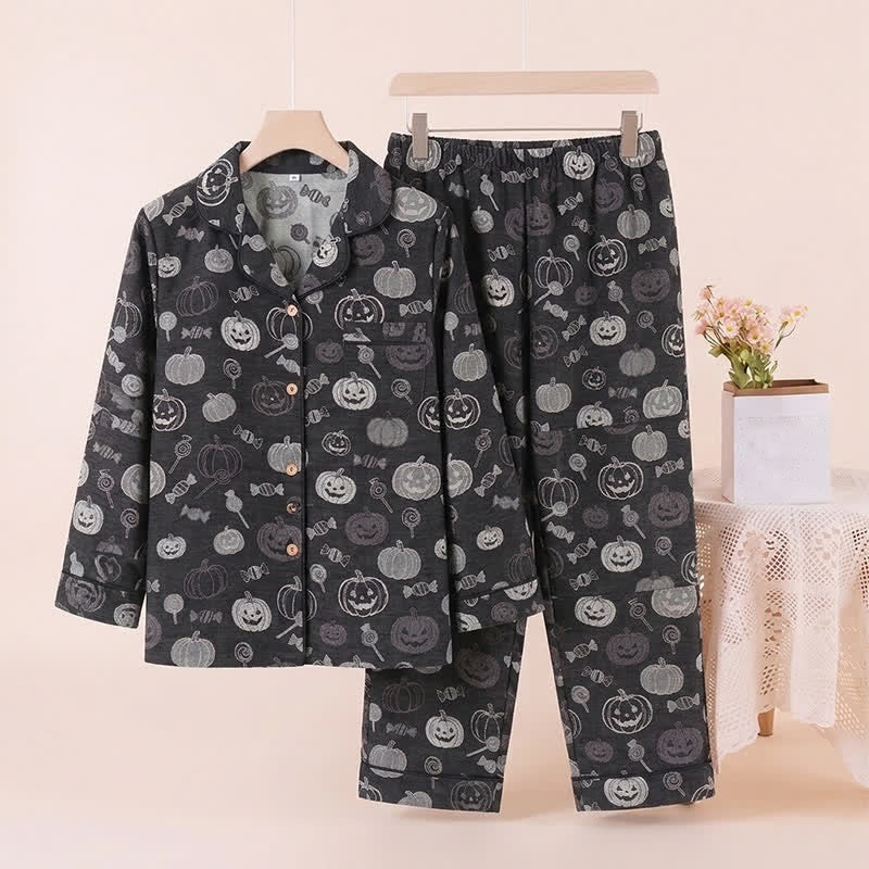 Zwarte pyjamaset met pompoenprint, hangend getoond op knaapje en standaard | Boutique Moda