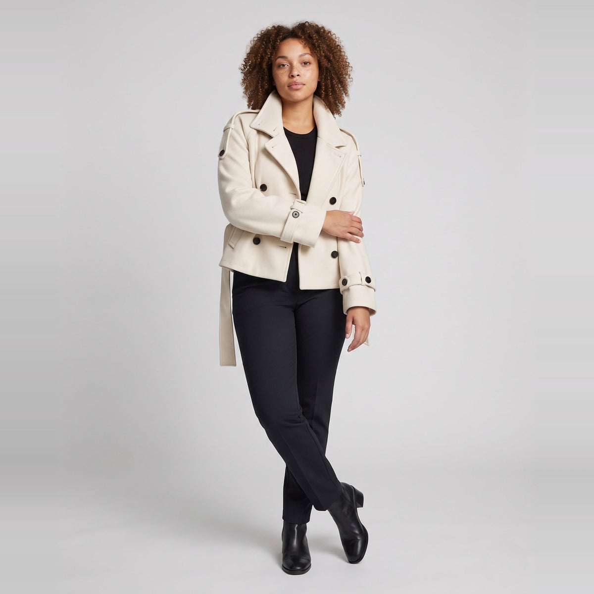 Beige korte capejas met omslagkraag, gedragen door vrouw met zwarte broek | Boutique Moda