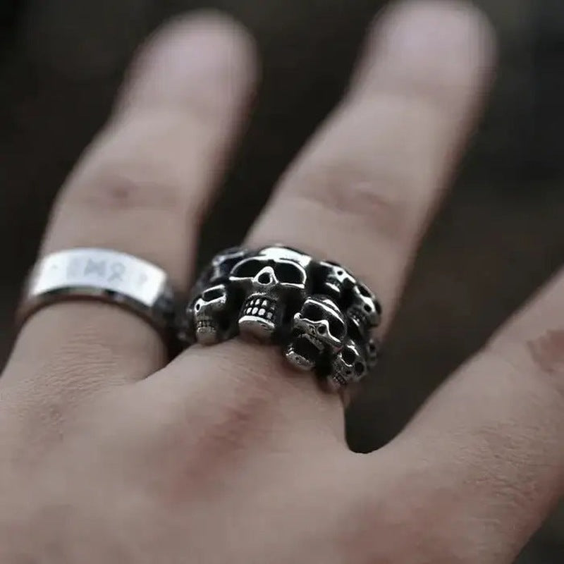 Zilverkleurige ring met meerdere schedels gedragen aan vinger, close-up foto | Boutique Moda