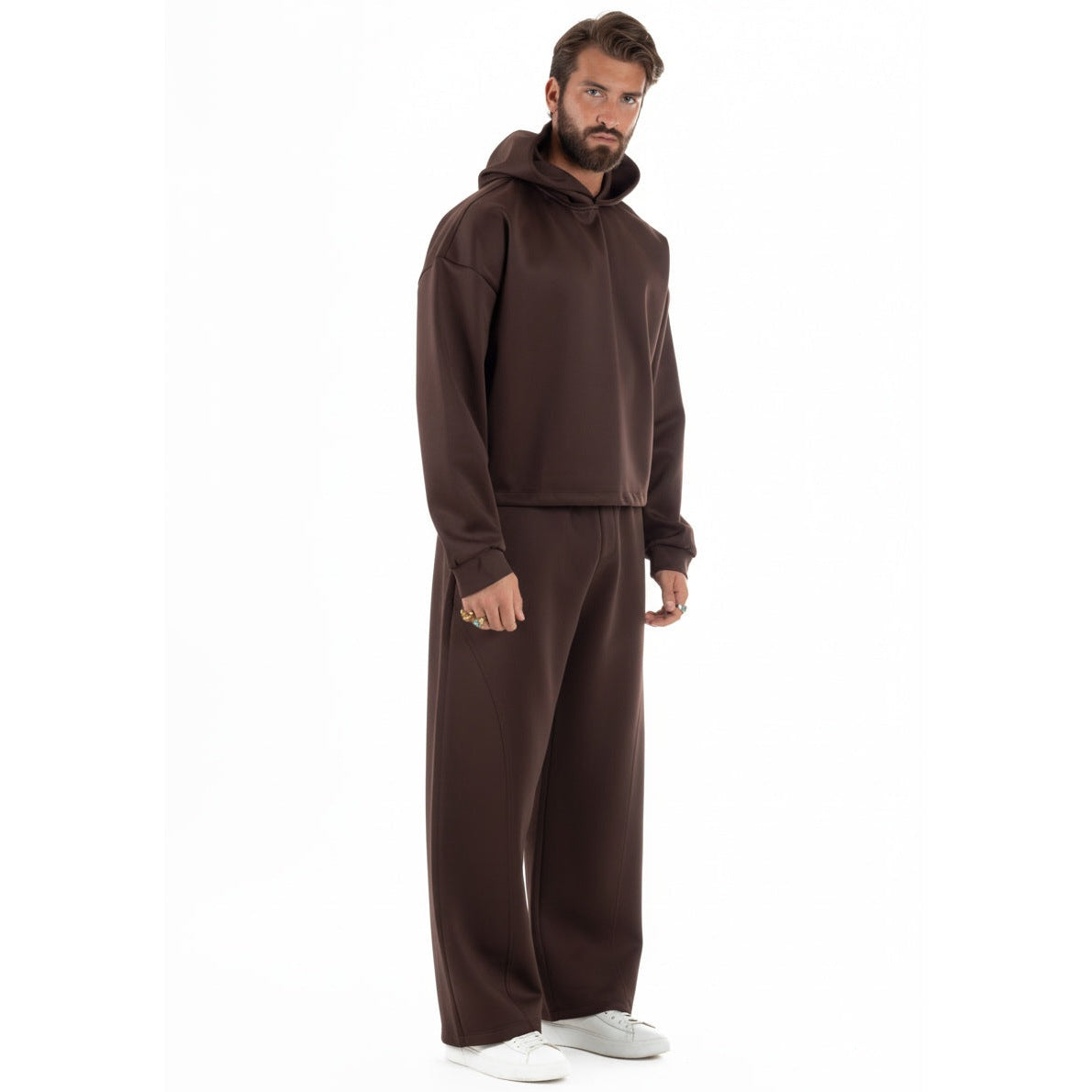 Man draagt bruine cropped hoodie met wijde broek, zijaanzicht | Boutique Moda