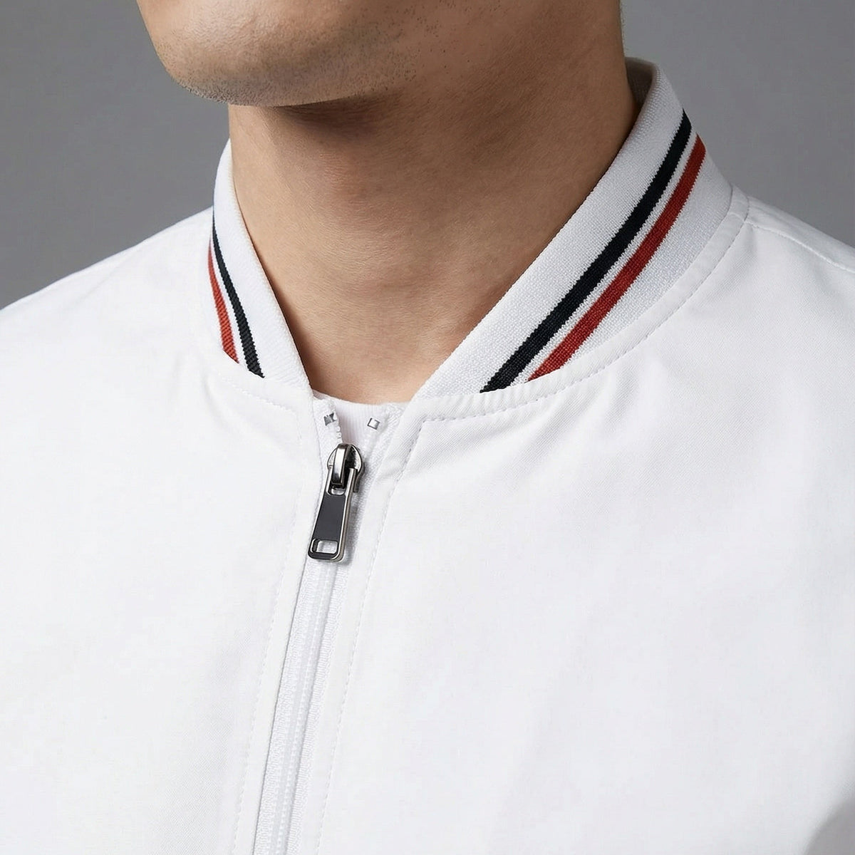Witte bomberjack met gestreepte boord, gedragen door model, close-up rits | Boutique Moda