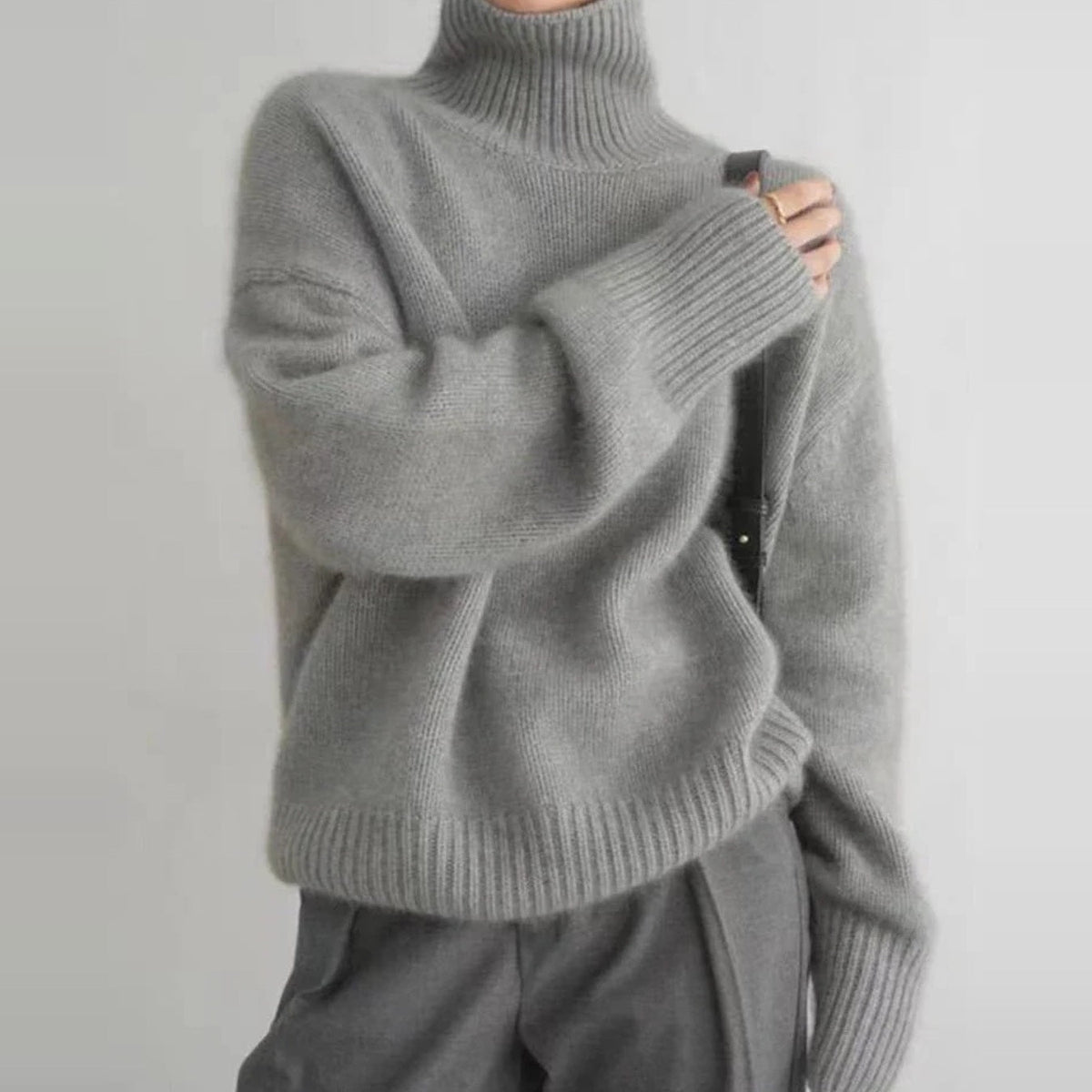 Grijze oversized coltrui met lange mouwen, gedragen door een persoon | Boutique Moda