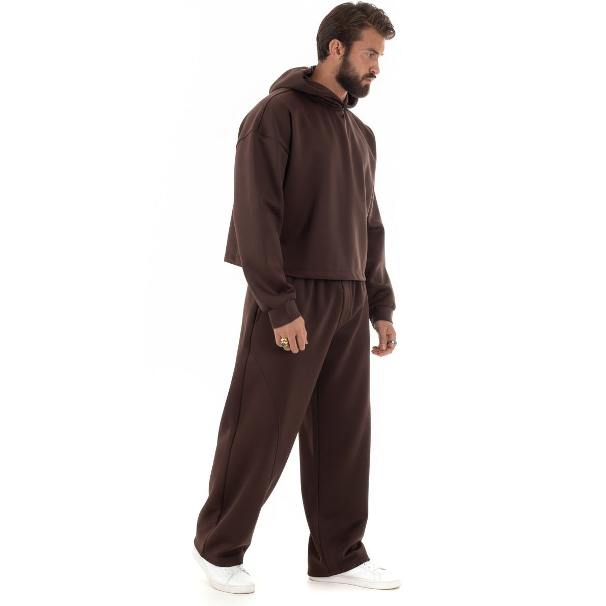 Man draagt bruine cropped hoodie set met wijde broek, zijaanzicht | Boutique Moda
