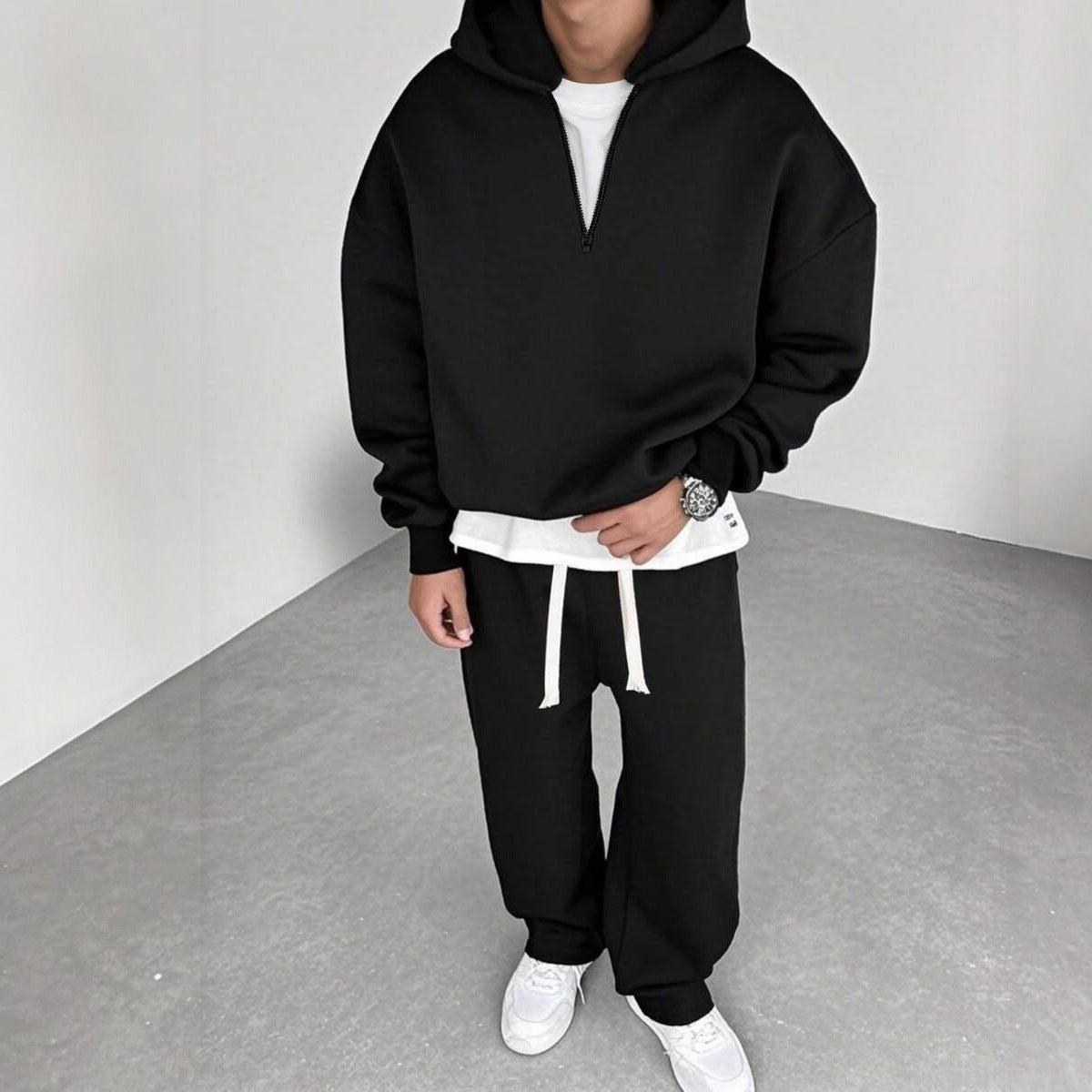 Zwart joggingpak met halfzip hoodie en wijde broek, gedragen door man | Boutique Moda
