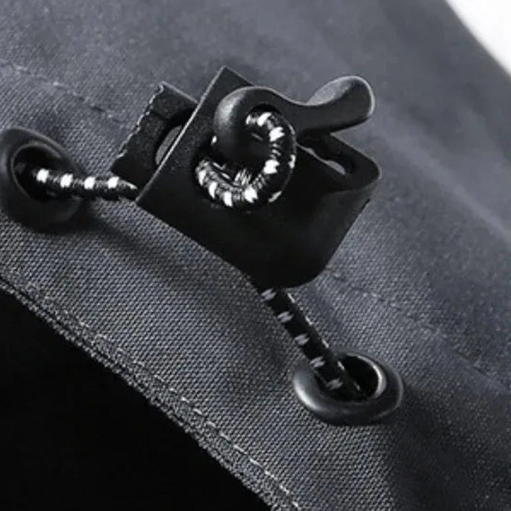 Close-up van zwarte verstelbare koordstopper met metalen oogjes op stof | Boutique Moda