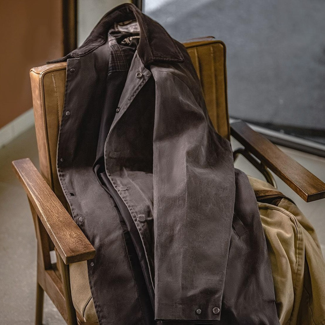 Bruine jas met corduroy kraag hangt over een houten stoel | Boutique Moda