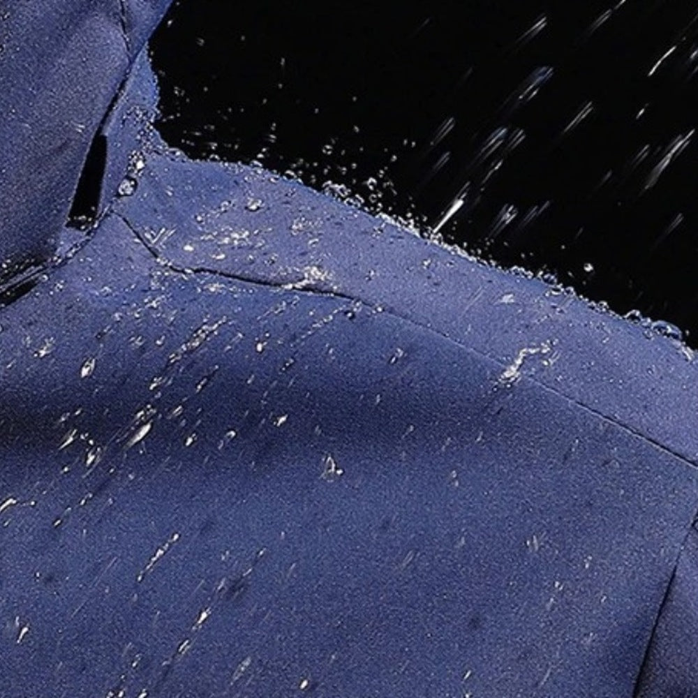 Blauwe waterdichte jas met capuchon, close-up van schouder met waterdruppels | Boutique Moda