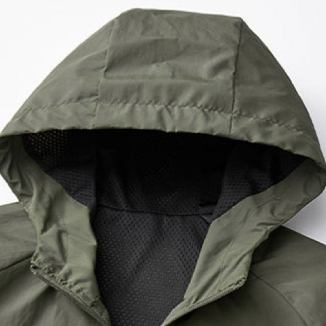 Groene windjas met capuchon en zwarte meshvoering, close-up detailfoto | Boutique Moda
