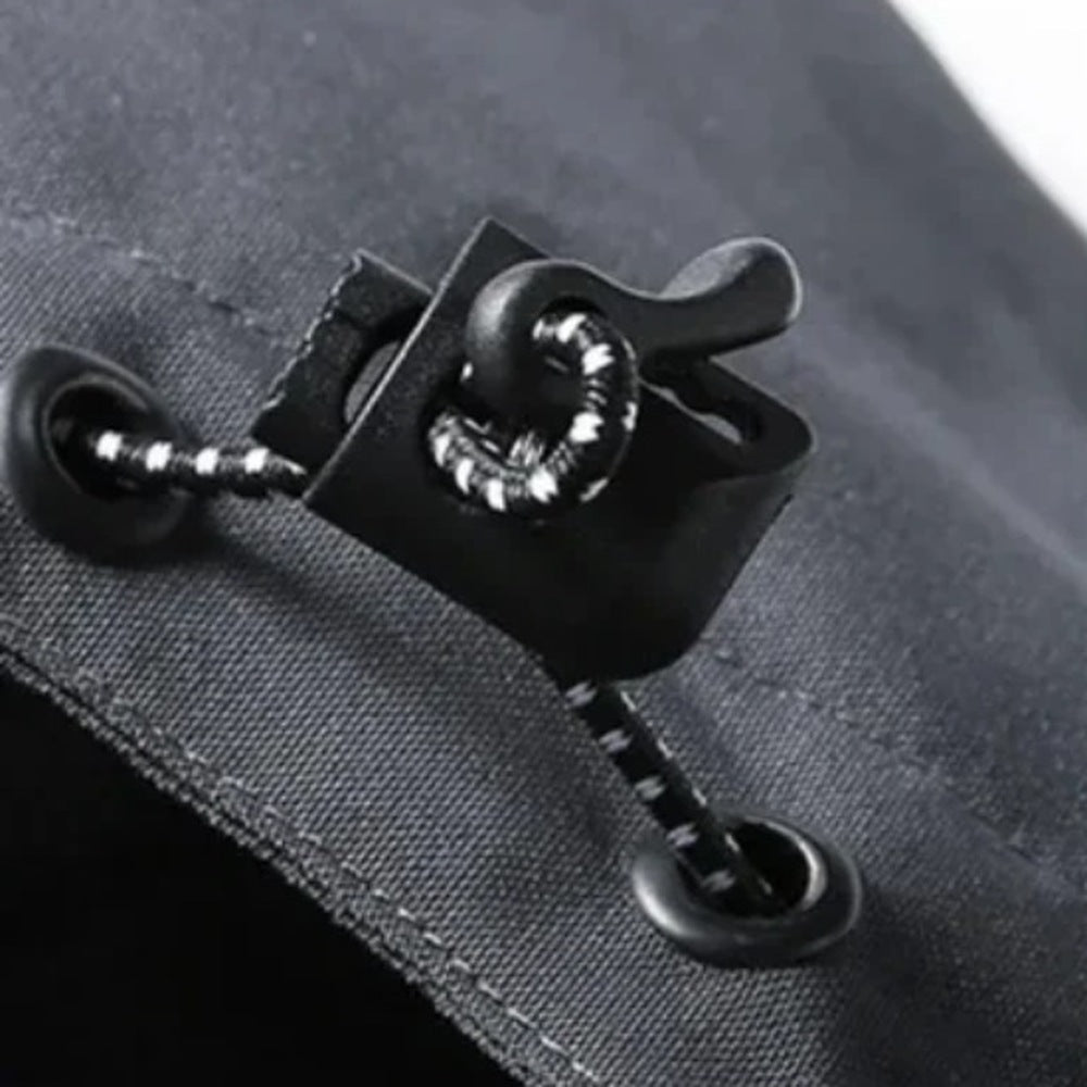 Zwarte haakbevestiging met kettingdetail op donkere jasstof, close-up weergave | Boutique Moda