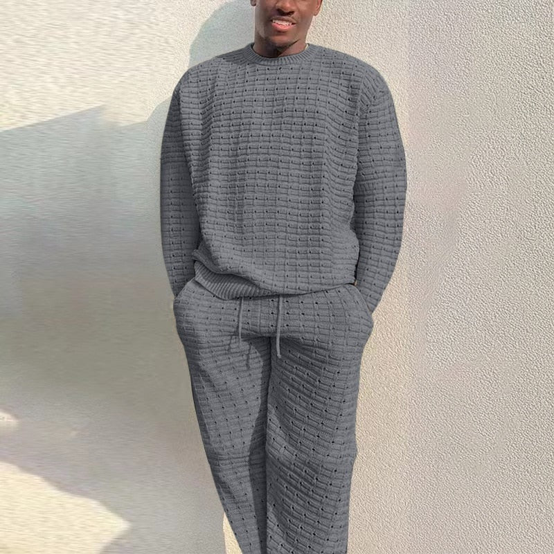 Grijze gebreide loungeset met trui en broek, gedragen door man buiten | Boutique Moda