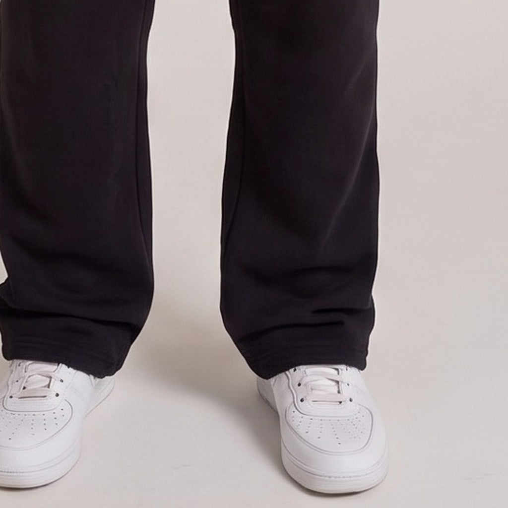 Zwarte joggingbroek met witte sneakers, close-up op benen en schoenen | Boutique Moda