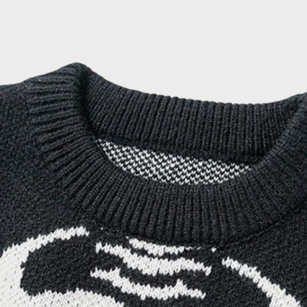 Close-up van zwarte gebreide trui met ronde hals en skeletpatroon | Boutique Moda