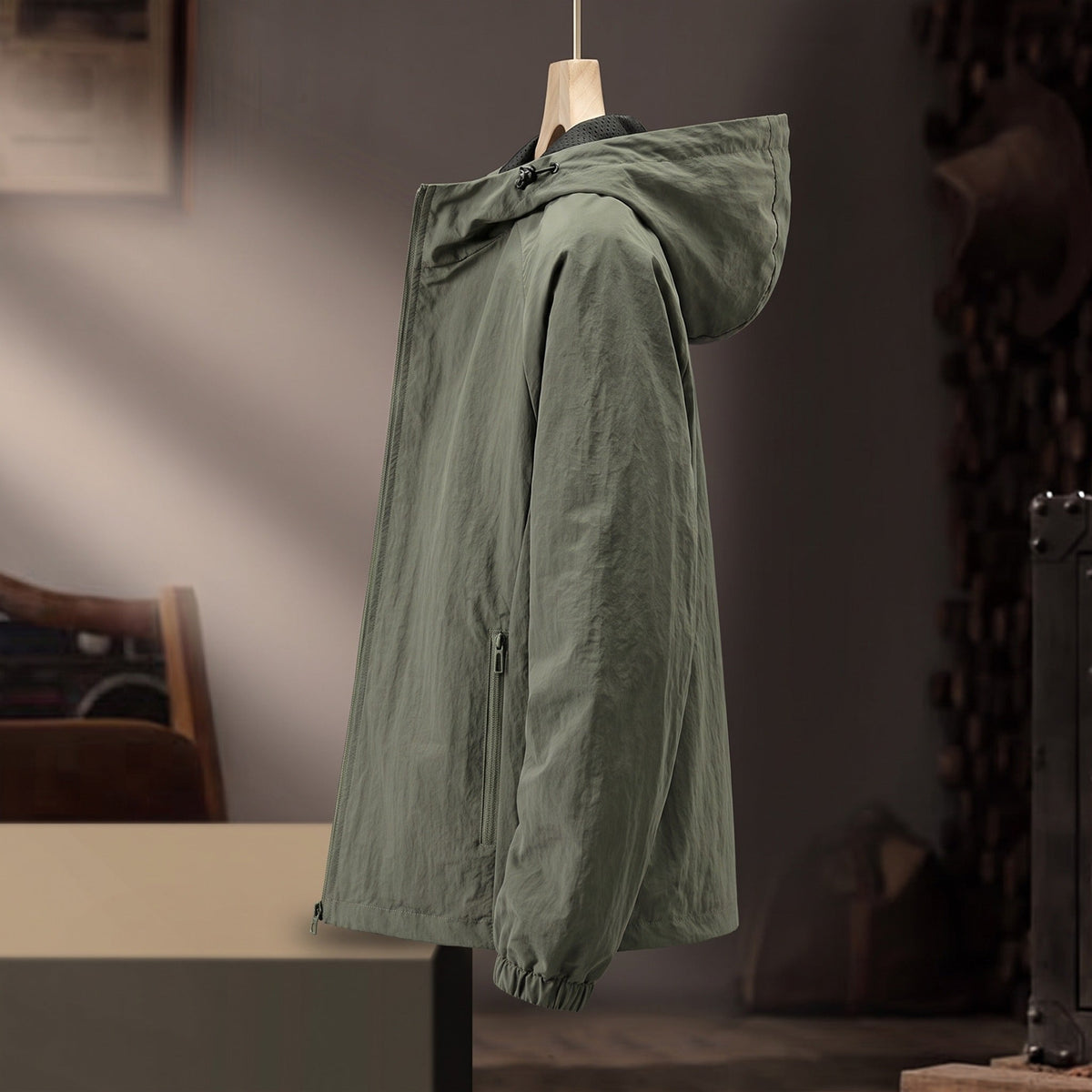 Groene windjas met capuchon hangend op kledinghanger, zijaanzicht | Boutique Moda