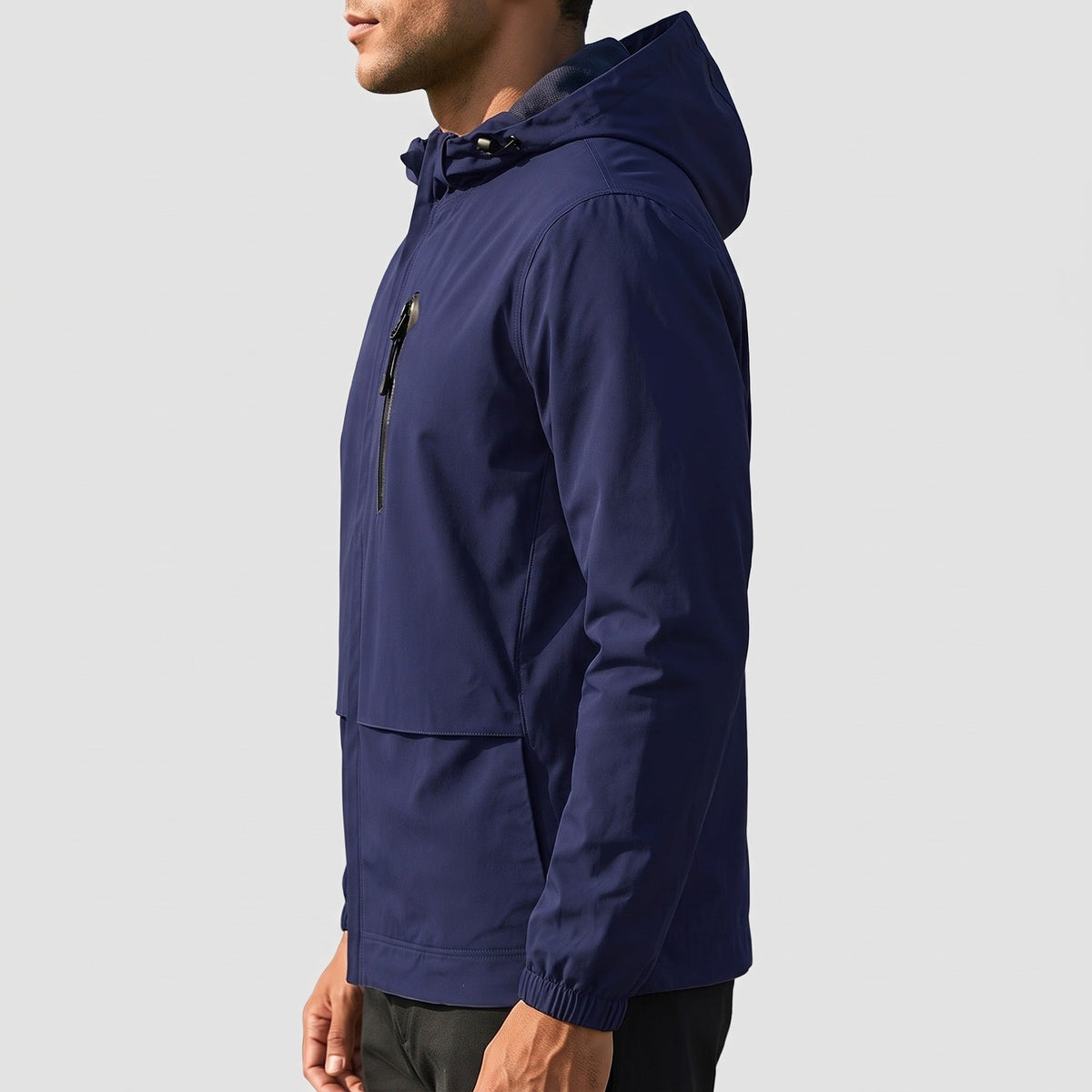 Donkerblauwe regenjas met capuchon en ritszak, gedragen door man, zijaanzicht | Boutique Moda