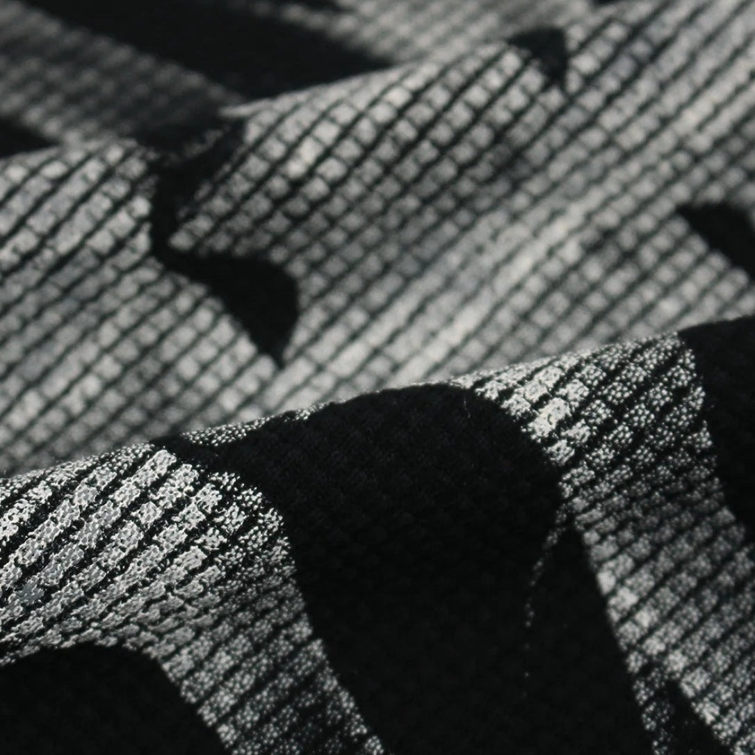 Close-up van zwart-wit geweven stof met wafelstructuur en golvend patroon | Boutique Moda