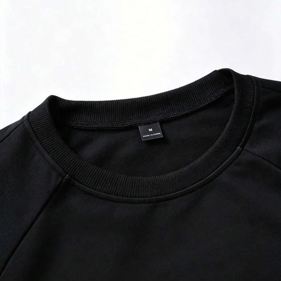 Zwarte sweater met ronde hals, close-up van kraag en label | Boutique Moda