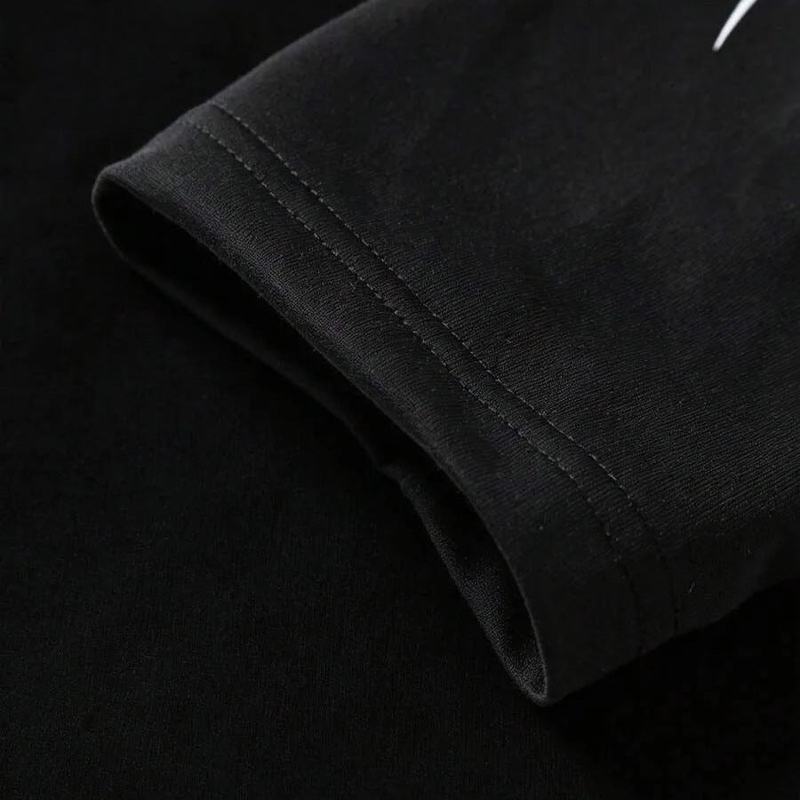 Zwarte mouw met dubbele stiknaad, close-up detailfoto van kledingstuk | Boutique Moda