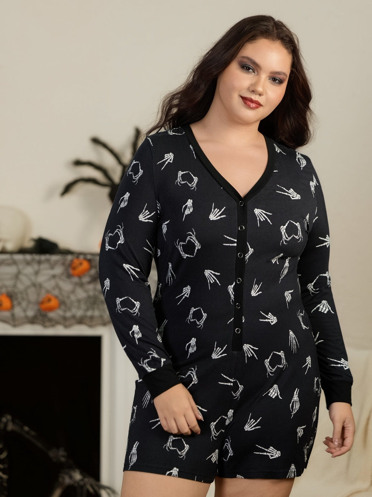 Vrouw in de zwarte skelet playsuit thuis met Halloween decoratie