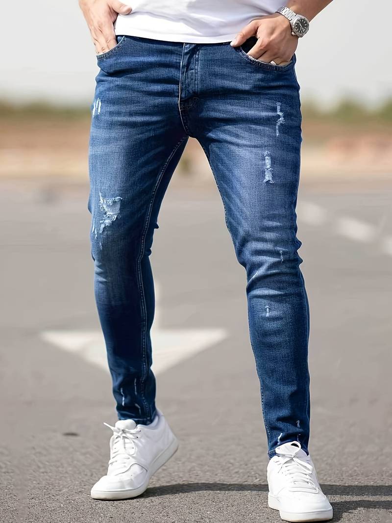 Indigoblauwe skinny spijkerbroek met scheuren gedragen