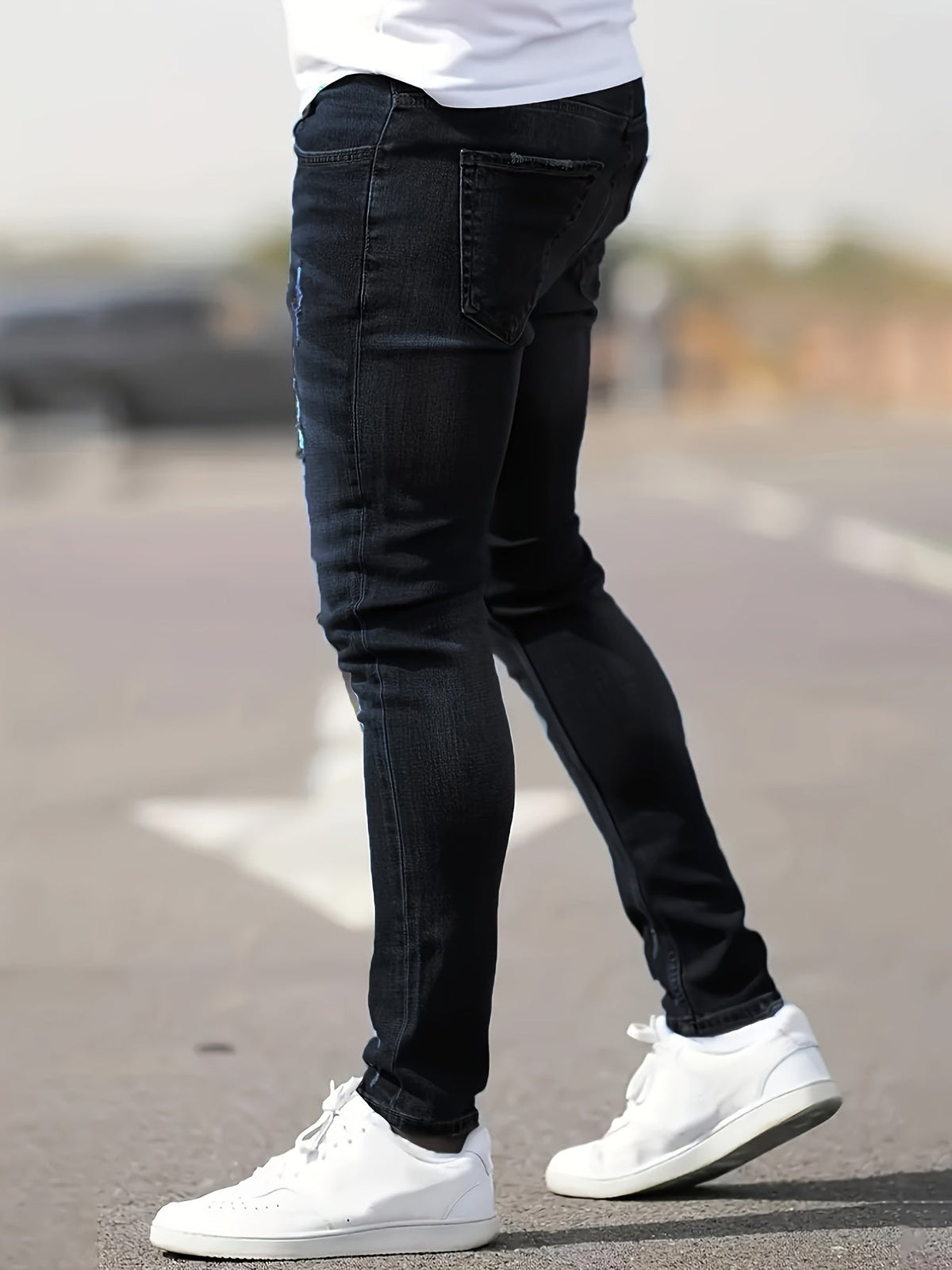 Zwarte skinny spijkerbroek met scheuren gedragen