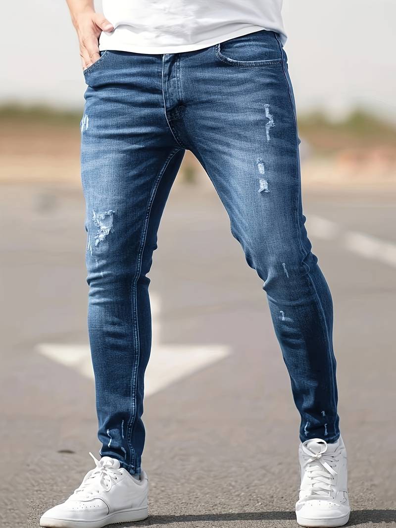 Middenblauwe skinny spijkerbroek met scheuren gedragen
