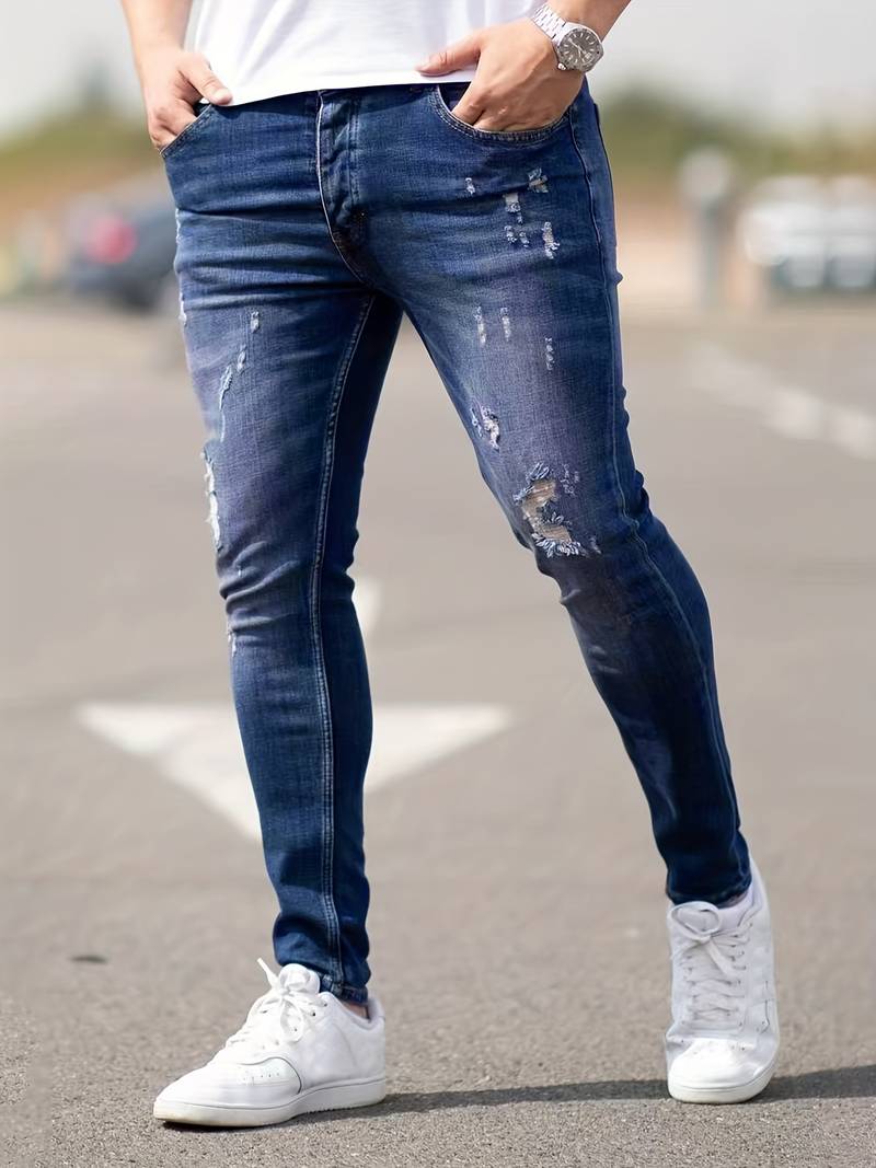 Donkerblauwe skinny spijkerbroek met scheuren gedragen