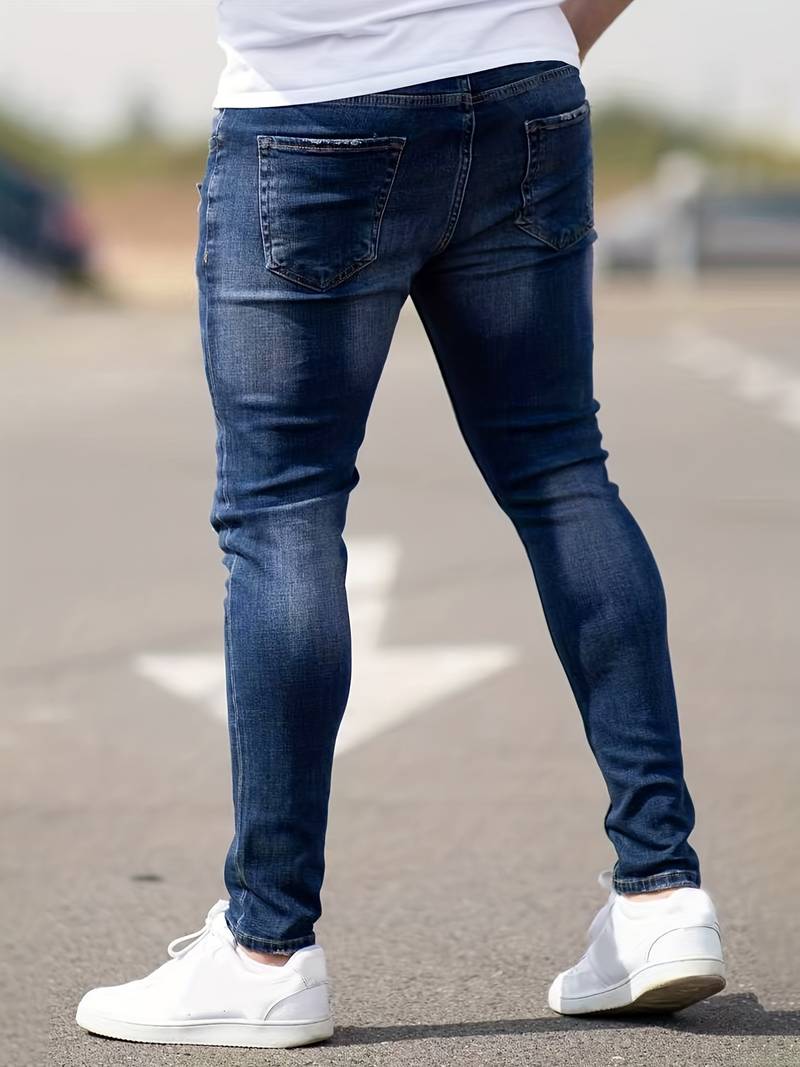 Donkerblauwe skinny spijkerbroek met scheuren gedragen