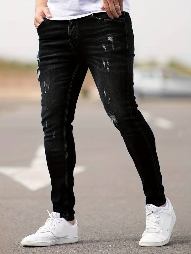 Grafietkleurige skinny spijkerbroek met scheuren gedragen