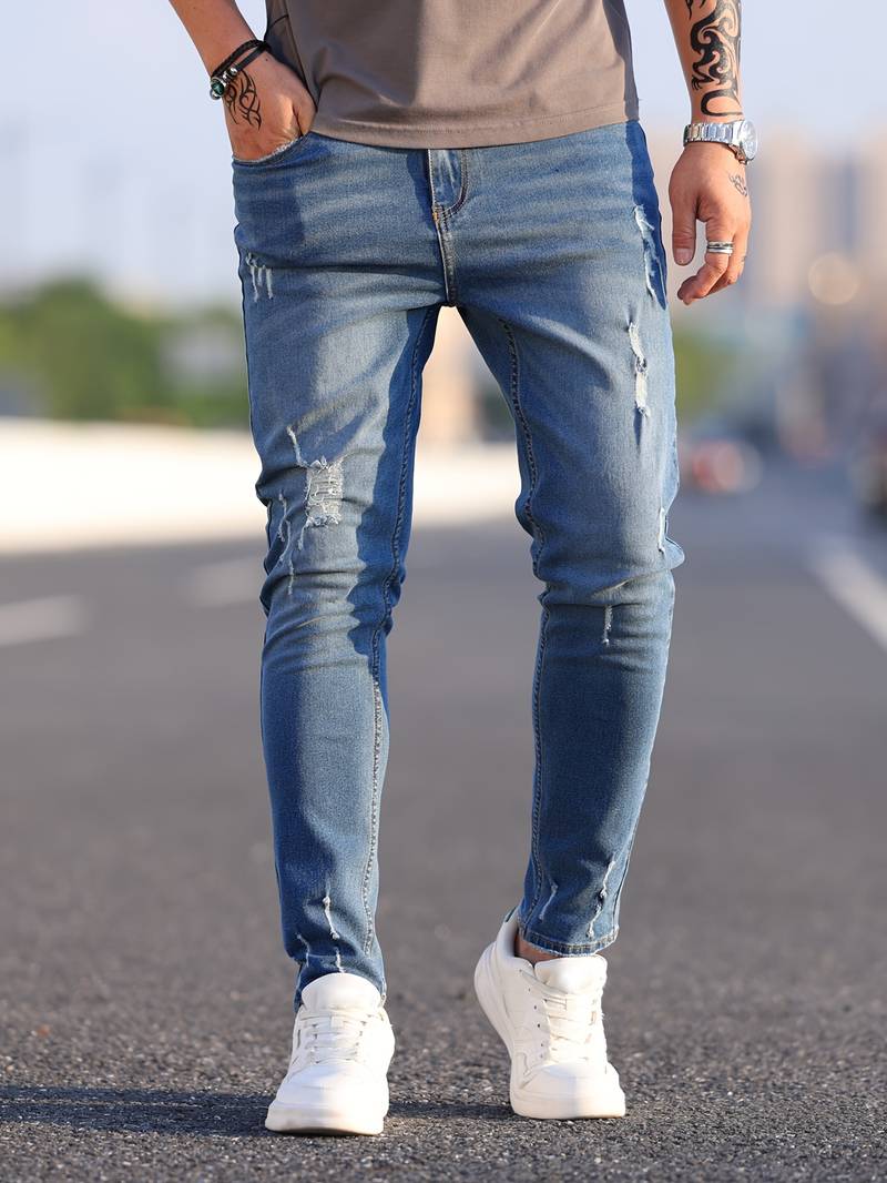 Verwassen blauwe skinny spijkerbroek met scheuren gedragen