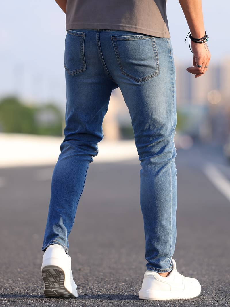 Verwassen blauwe skinny spijkerbroek met scheuren gedragen