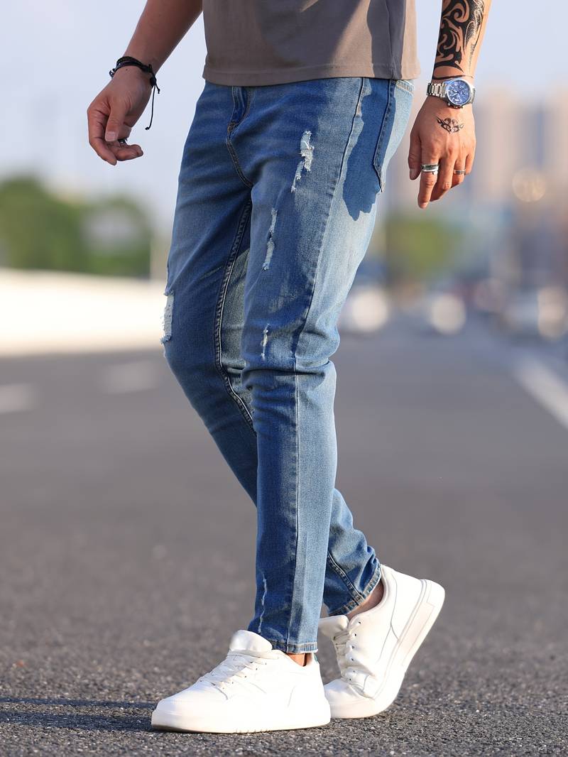 Verwassen blauwe skinny spijkerbroek met scheuren gedragen