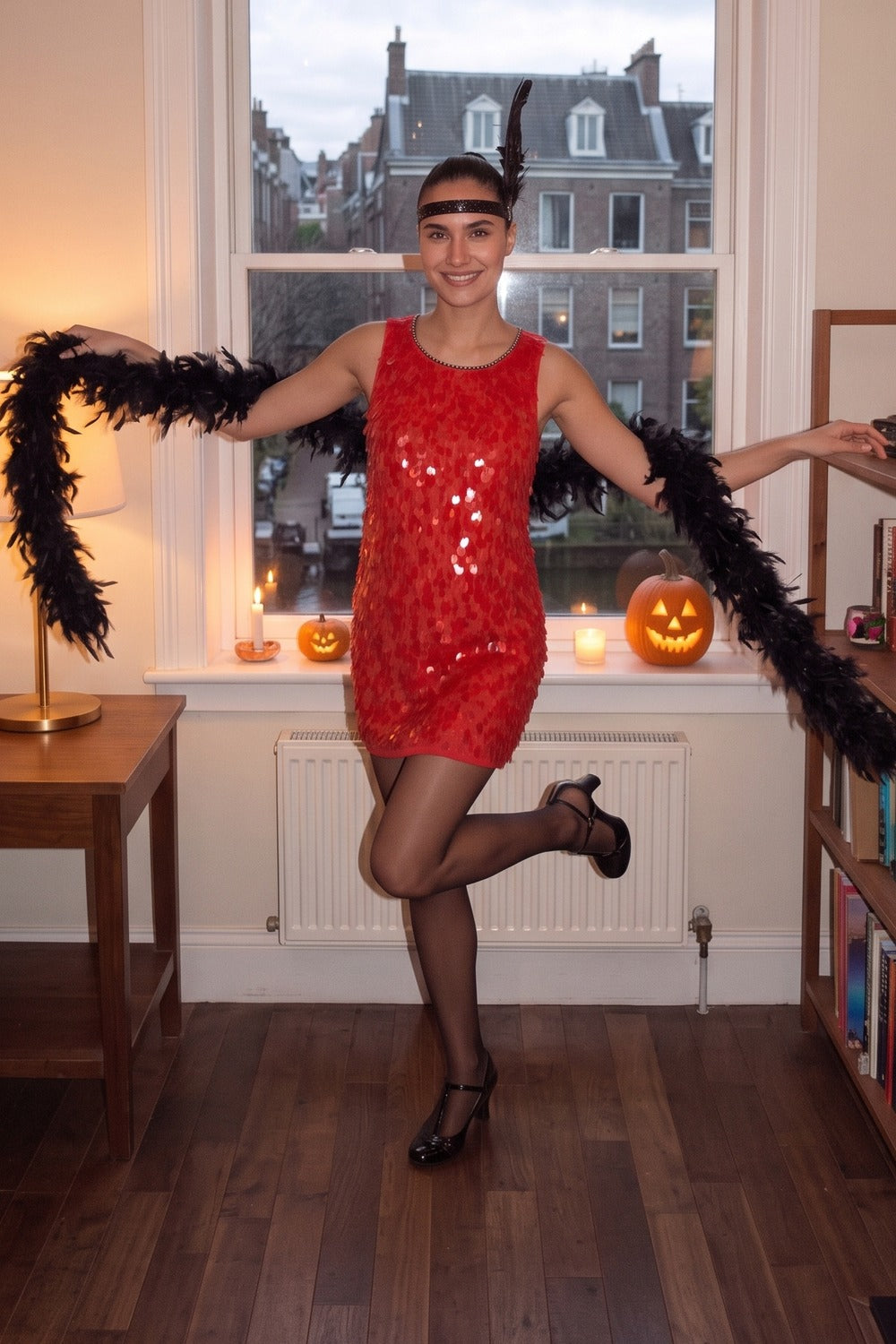 Vrouw in de rode charlestonjurk met verenhoofdband en boa op een Halloweenfeest