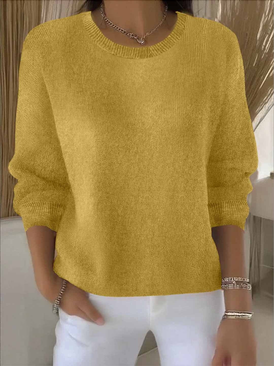 Fijngebreide oversized damestrui in mosterdgeel met ronde hals, gedragen op een witte broek