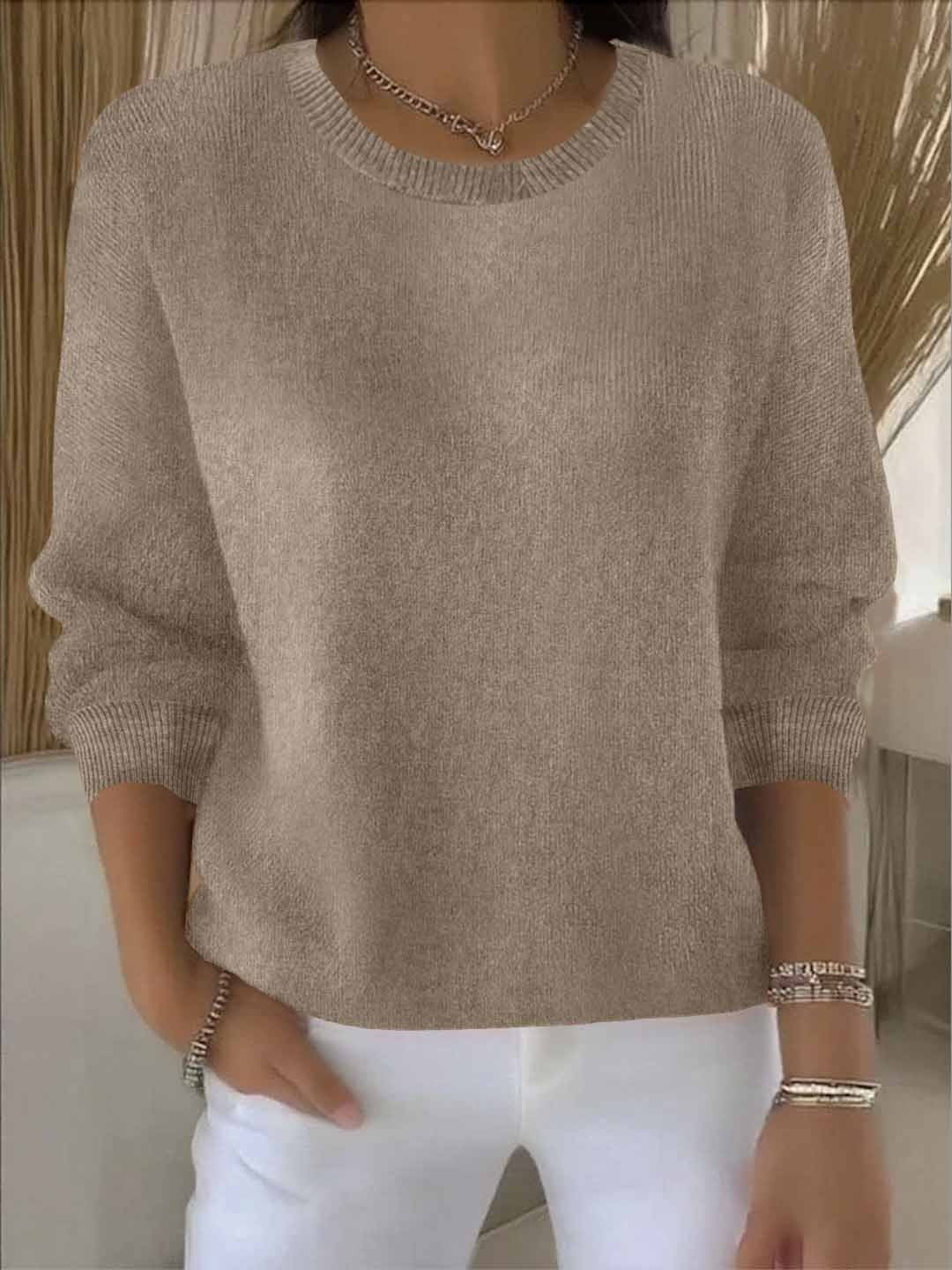 Fijngebreide oversized damestrui in taupe met ronde hals, gedragen op een witte broek