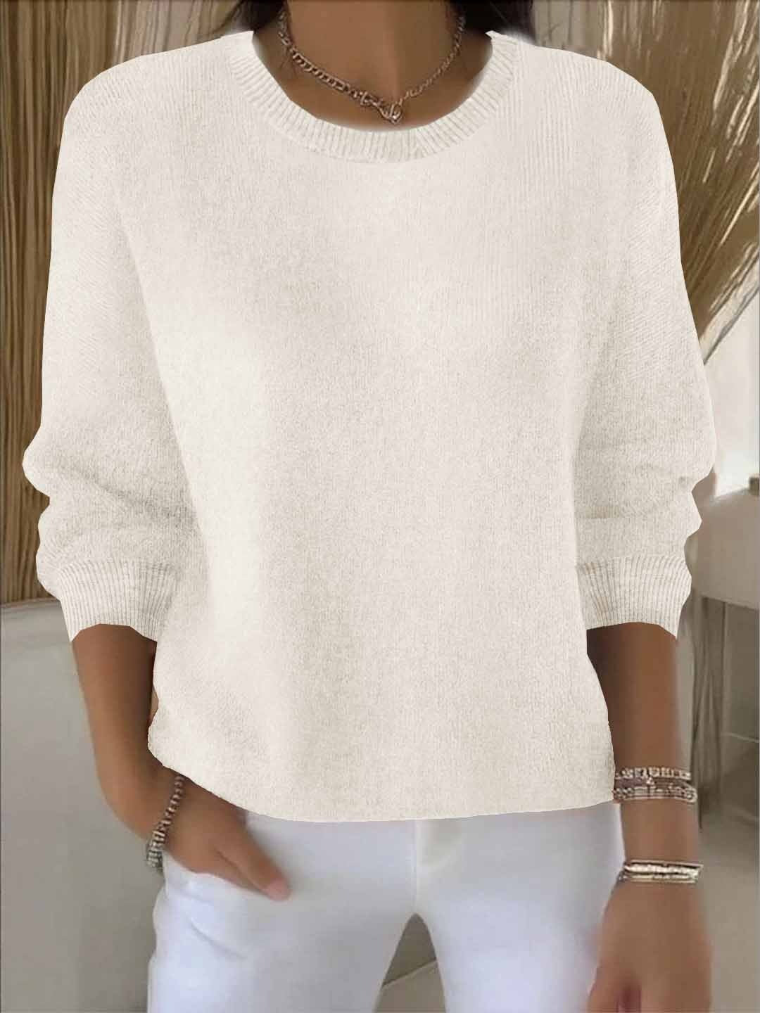 Fijngebreide oversized damestrui in crème met ronde hals, gedragen op een witte broek