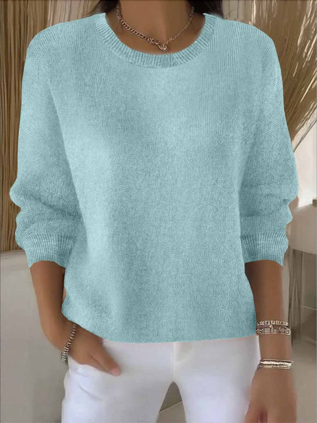 Fijngebreide oversized damestrui in mintgroen met ronde hals, gedragen op een witte broek