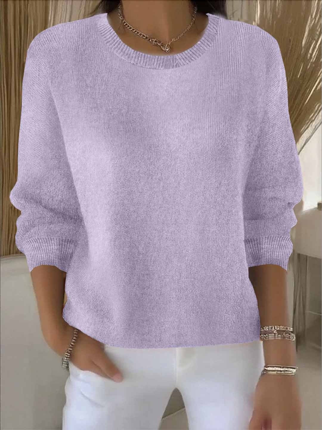 Fijngebreide oversized damestrui in lila met ronde hals, gedragen op een witte broek