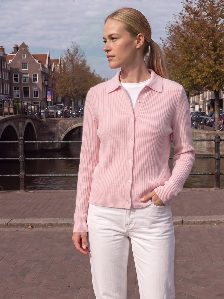 Vrouw in een roze vest met knopen en overhemdkraag aan een Amsterdamse gracht