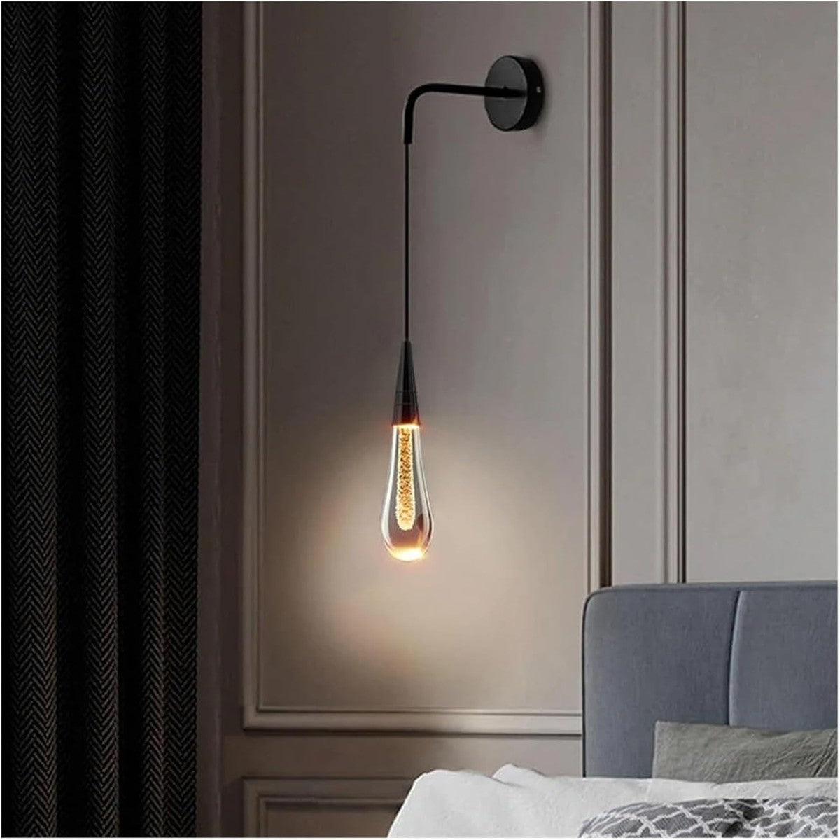 Zwarte wandlamp met waterdruppelvormig glas naast een bed | Boutique Moda
