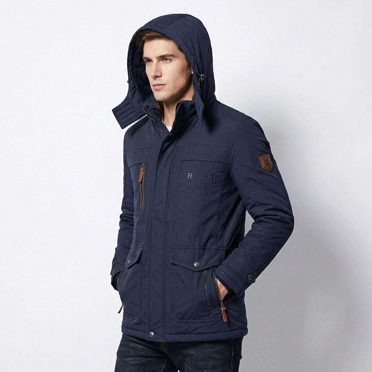 Man draagt donkerblauwe winterparka met capuchon op, handen in de zakken | Boutique Moda
